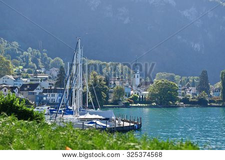 Vitznau, Switzerland 29.09.2019: Sailing Boats Parking In A Port On Lake Lucerne With The Church Tow