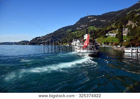 Vitznau, Switzerland 29.09.2019: A Steamboat With Swiss Flag On The Back And With Tourist Is Leaving