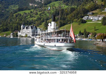 Vitznau, Switzerland 29.09.2019: A Steamboat With Swiss Flag On The Back And With Tourist Is Leaving