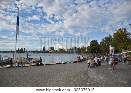 Zug, Switzerland 29.09.2019: People Walking, Relaxing At The Boardwalk On The Lake Zug Lakeshore