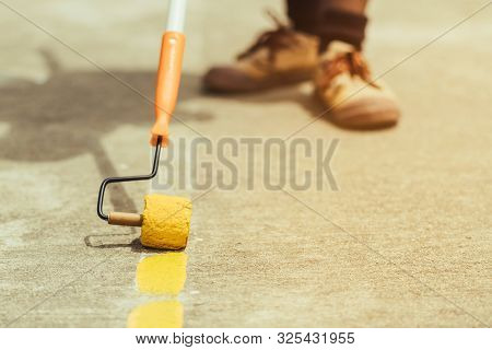 Male Students Use Small Paint Rollers To Paint Yellow Lines On The Cement Floor For Sepak Takraw Tra