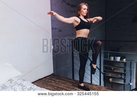 Attrctive Fitness Woman Doing Stretching Exercises At Home, As Part Of A Healthy Lifestyle Without G
