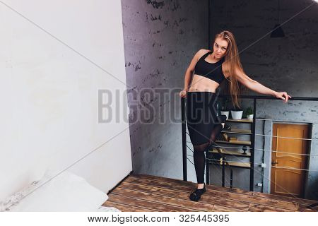 Attrctive Fitness Woman Doing Stretching Exercises At Home, As Part Of A Healthy Lifestyle Without G