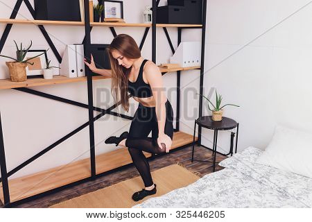 Attrctive Fitness Woman Doing Stretching Exercises At Home, As Part Of A Healthy Lifestyle Without G