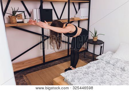Attrctive Fitness Woman Doing Stretching Exercises At Home, As Part Of A Healthy Lifestyle Without G