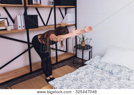 Attrctive Fitness Woman Doing Stretching Exercises At Home, As Part Of A Healthy Lifestyle Without G