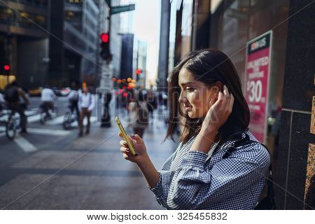 Brunette Girl Using Her Cellphone To Reach A Friend
