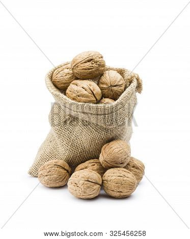 Pile Of Walnuts In Juta Bag On White Background