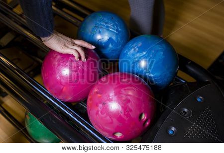 Close-up Hand Holding Bowling Ball Against Bowling Alley - Image. Cheerful Woman Isready To Play - I