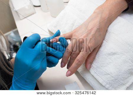 Close-up Of Professional Making Manicure With  Transparent Glossy Acrilyc . Specialist Beautician In