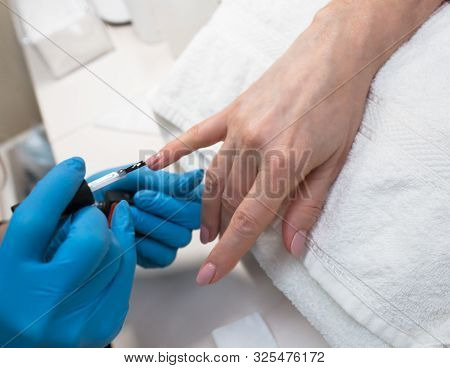 Close-up Of Professional Making Manicure With  Transparent Glossy Acrilyc . Specialist Beautician In