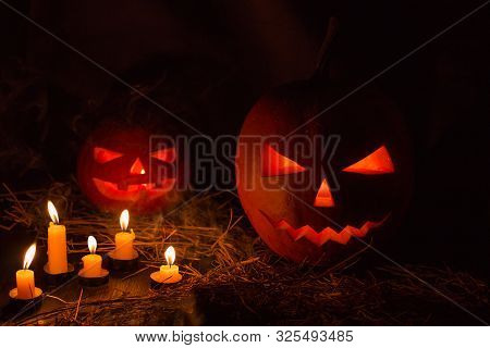 Helloween Pumpkin With Candles  On Black Background. Big Spooky Helloween Symbol. Selective Focus