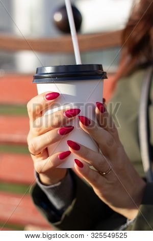 A Woman's Hand Holding A White Coffee Cup