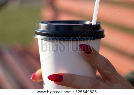 A Woman's Hand Holding A White Coffee Cup