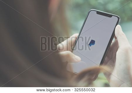 Chiang Mai, Thailand - Jun 22 2019: Woman Holding A Iphone X With Service Paypal On The Screen. Payp