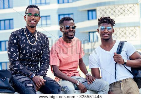 A Group Of Three Fashionable Cool African American Guys Students Communicating On The Street