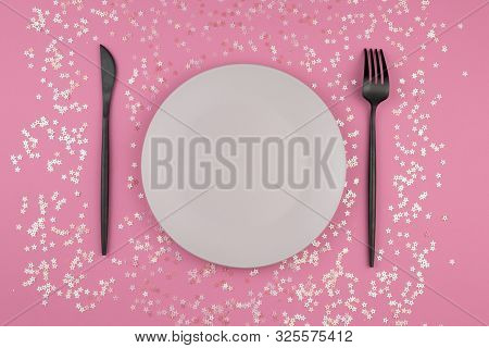 Empty Plate And Modern Cutlery On Pinck Background With Star Sprinkles. Festive Holiday Background. 