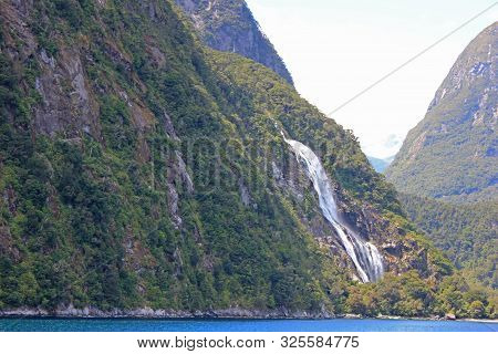 gigantic watefall at milford sound, new zealand