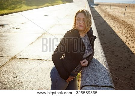 Happy Young Curvy Woman Looking Up Outdoors In Fall. Girl Enjoying Warm Sunny Weather. She Wearing I