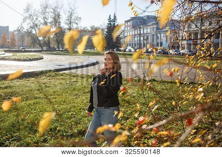 Happy Young Curvy Woman Looking Up Outdoors In Fall. Girl Enjoying Warm Sunny Weather. She Wearing I