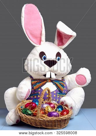 An Easter Bunny Sitting With A Basket Of Easter Eggs
