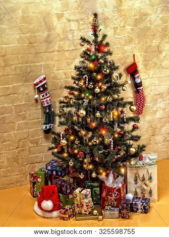 A Decorated Christmas Tree With A Pile Of Gifts