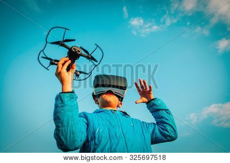 Young Boy Flying Drone In Virtual Reality Glasses In Nature