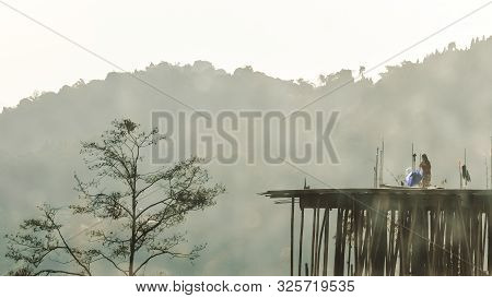 An Unrecognizable Young Woman In The Far Distance Standing On Rooftop Of An Old Under Construction B