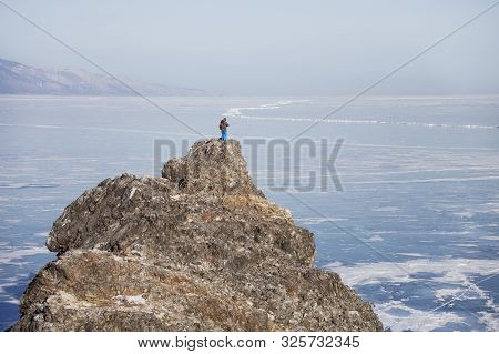 Traveler On Top Of The Oltrek Island Cape Lake Baikal. Winter Landscape