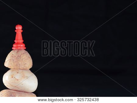 Red Pawn On Stone And Black Backgrouund