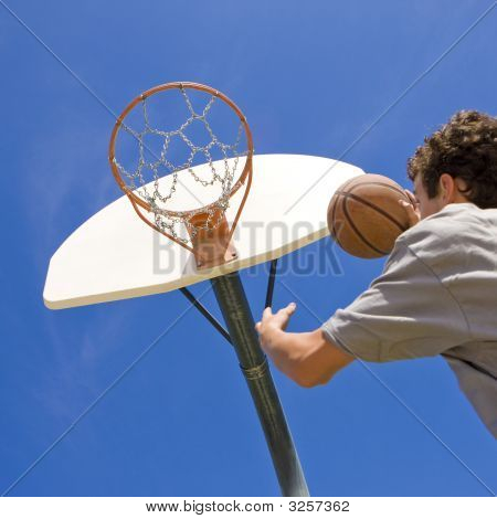 Basketbalový hráč skočí na obruč