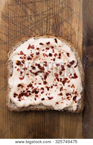 Slice of toast bread with chili mayonnaise and hot pepper flakesfrom above