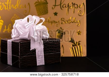 Brown Lether Box Decorated With White Ribbons And Carry Bag On Black Background. Birthday Gift Conce