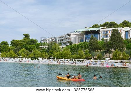 Rovinj, Croatia, August 22: Citizens And Tourists Sunbathe On Mulini Beach And Swim In The Clear Wat