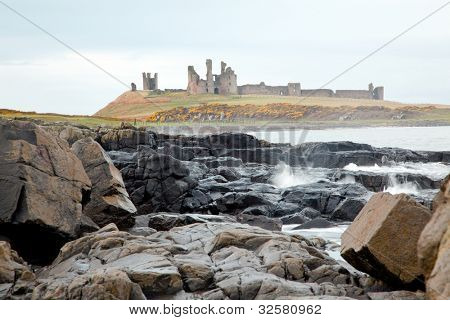 Dunstanburgh castle na severovýchodním pobřeží ve Velké Británii poblíž Craster v Northumberland