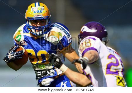 GRAZ, AUSTRIA - 9 aprile WR Wolfrum Hofbauer (#80 Giants) è affrontato bz DB Christoph Putz (#28 Viking