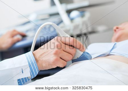 Ultrasound Procedure Of Pregnant Woman. Obstetrician Moving Transducer On Belly Of Future Mother. Pr