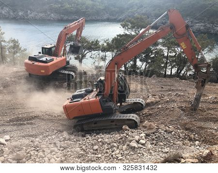 Hydrohammer Is Crushing Rocks During Road Construction Works On The Rocky Soils. Heavy Machinery At 