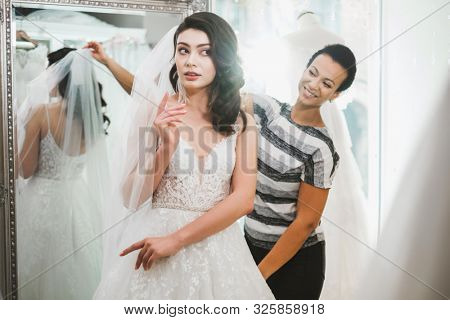 Beautifu bride choosing wedding dress in a wedding salon