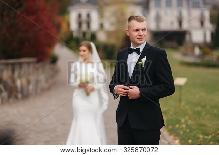 Stylish Couple Walking In The Park At Their Wedding Day. Happy Newlyweds Outside In Autumn Weather. 
