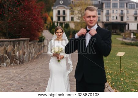 Stylish Couple Walking In The Park At Their Wedding Day. Happy Newlyweds Outside In Autumn Weather. 