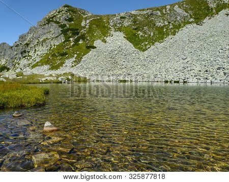 Mountain Landscape And Glacial Taul Portii Lake In Retezat National Park, Carpathian Mountains, Roma