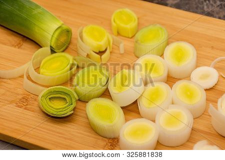 Organic Fresh Cutted Leeks On The Wooden Cutting Board. Leek Cut By Means Rings On A Chopping Board.
