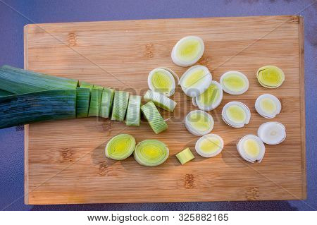 Organic Fresh Cutted Leeks On The Wooden Cutting Board. Leek Cut By Means Rings On A Chopping Board.