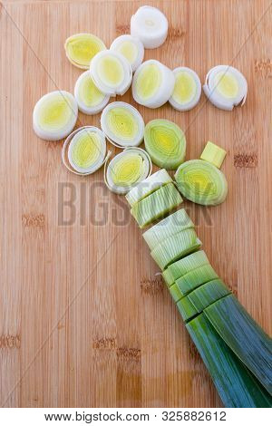Organic Fresh Cutted Leeks On The Wooden Cutting Board. Leek Cut By Means Rings On A Chopping Board.
