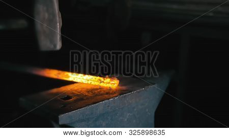 Forge Workshop. Smithy Manual Production. Hands Of Smith With Hammer Hit On Glowing Hot Metal, On Th