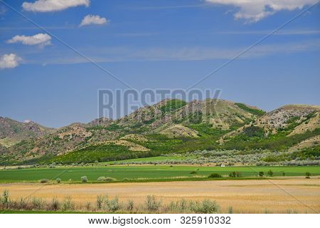 Summer Scene Of Flat Field And Rocky Hill, Macin Mountains In Romania