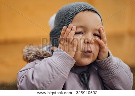Baby Girl Surprised With Hands On Her Head. Outddors Winter Day. Wow