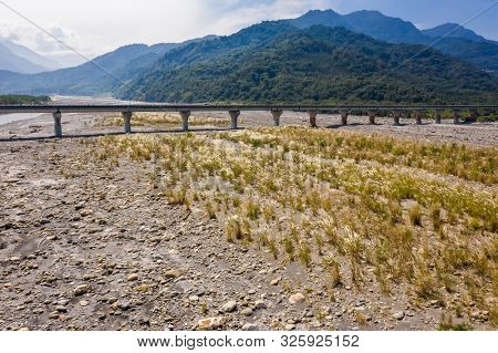 bridge over river with golden miscanthus under sky