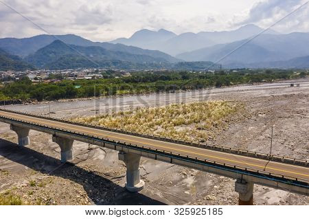 bridge over river with golden miscanthus under sky